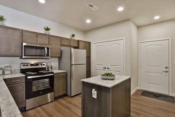 a kitchen with stainless steel appliances and wooden cabinets  at Aventura at Hawk Ridge, Missouri, 63367